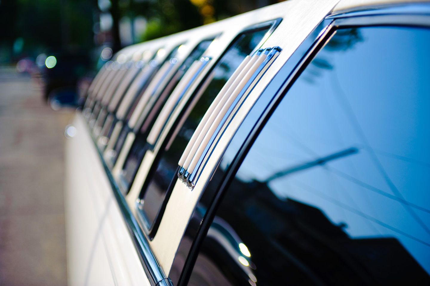 A white limousine is parked on the side of the road.