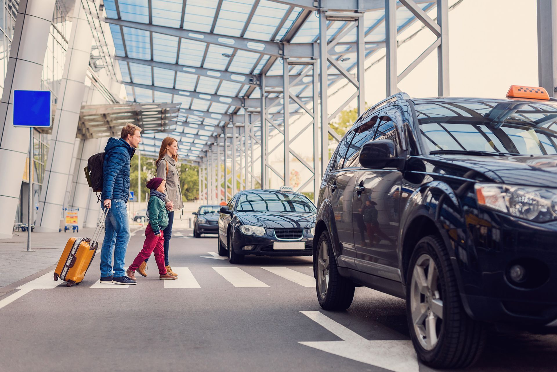 A family is waiting for a taxi at the airport.