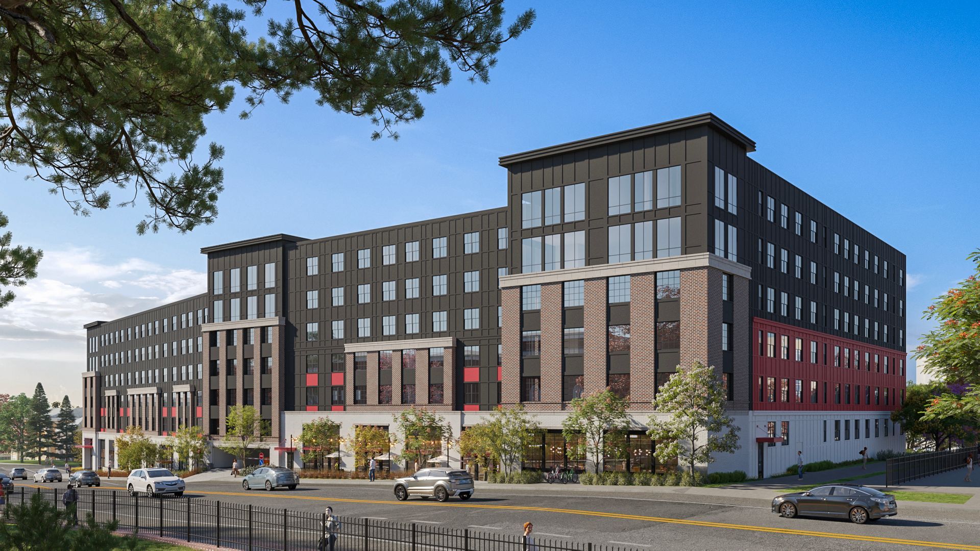 Modern multi-story apartment building with street-level storefronts, dark siding, and red brick accents.