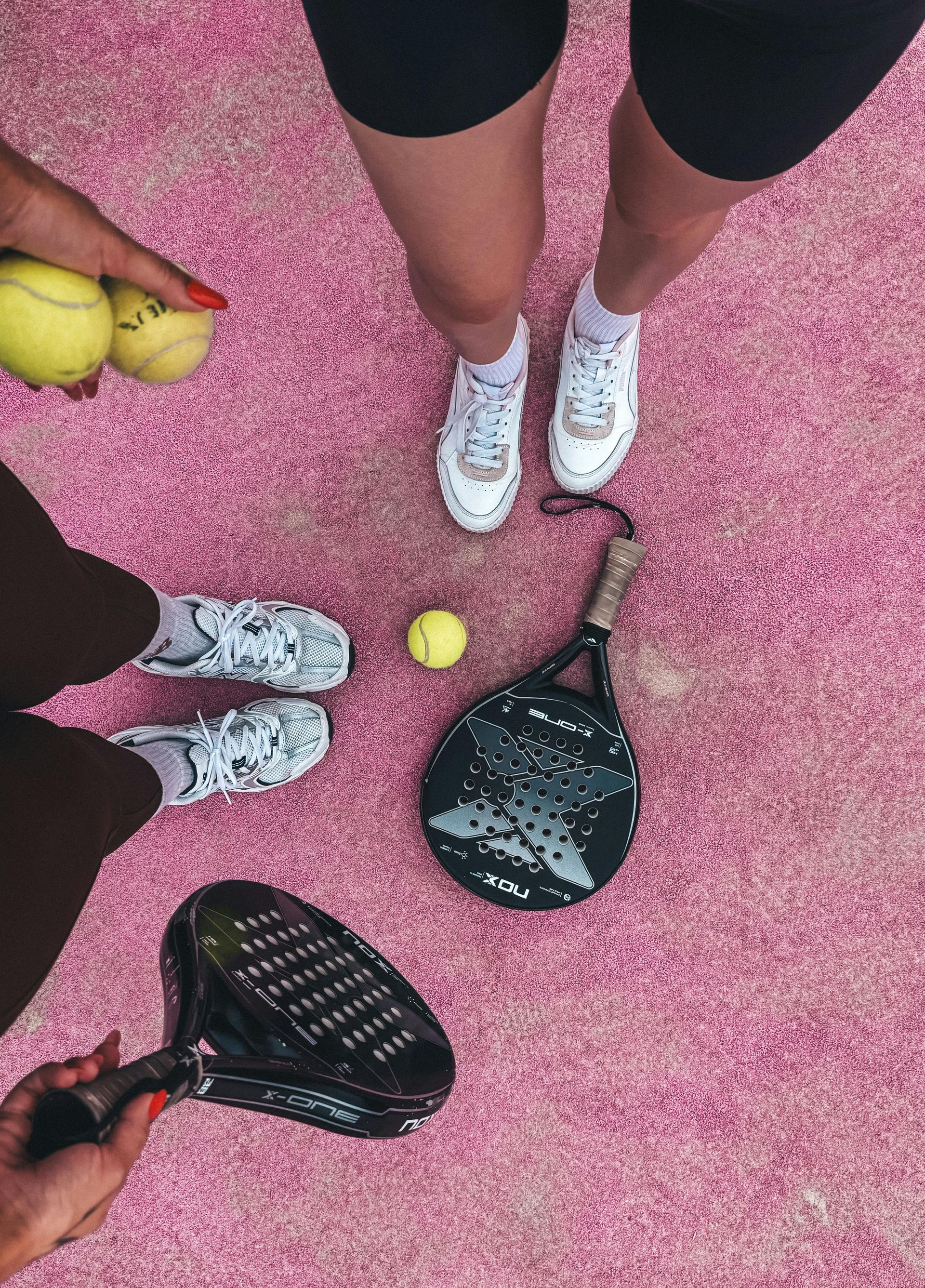 Blue sofa with pillows in front of two framed landscape photos, floor lamp, and a marble coffee table.