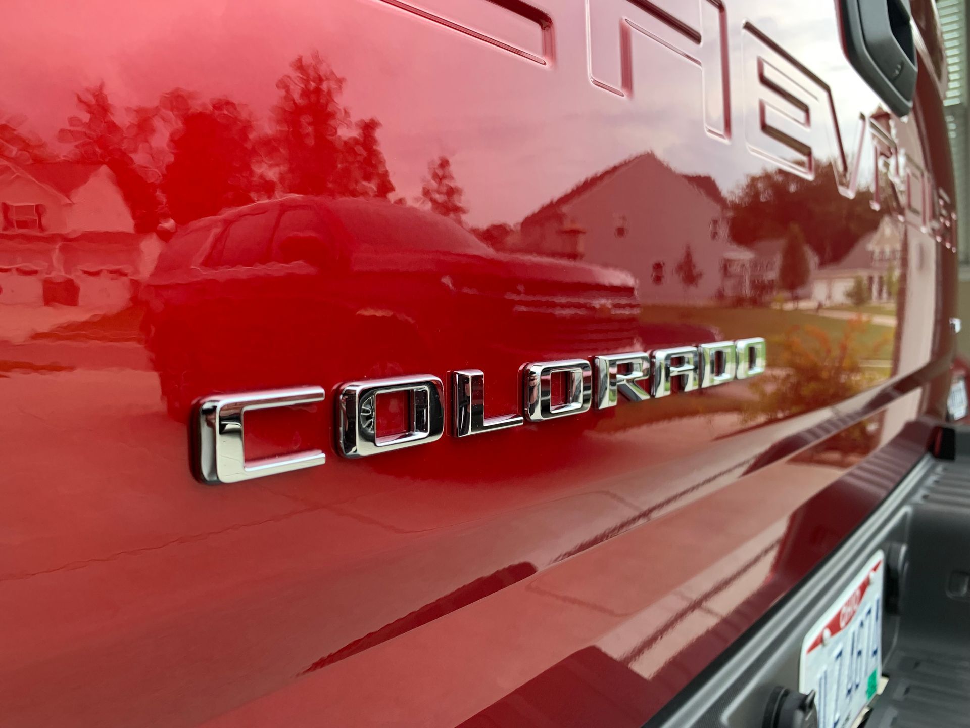 A red colorado truck is parked in a driveway