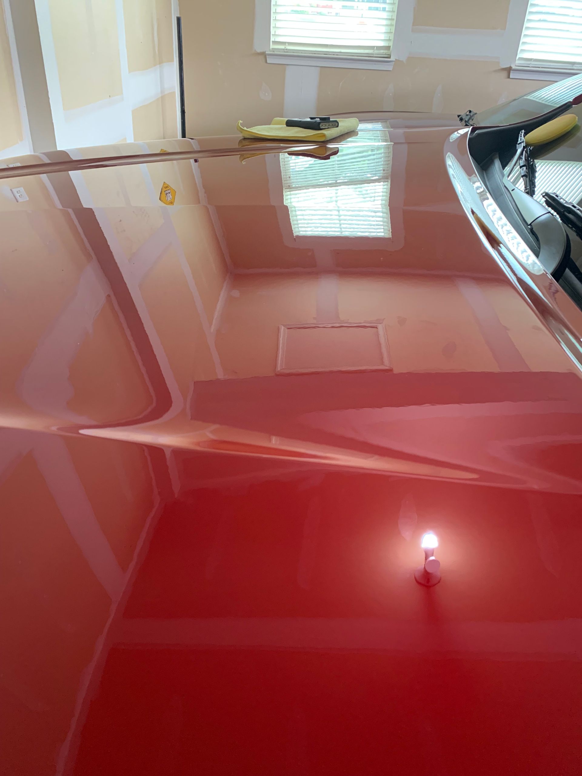 A red car is parked in a garage.