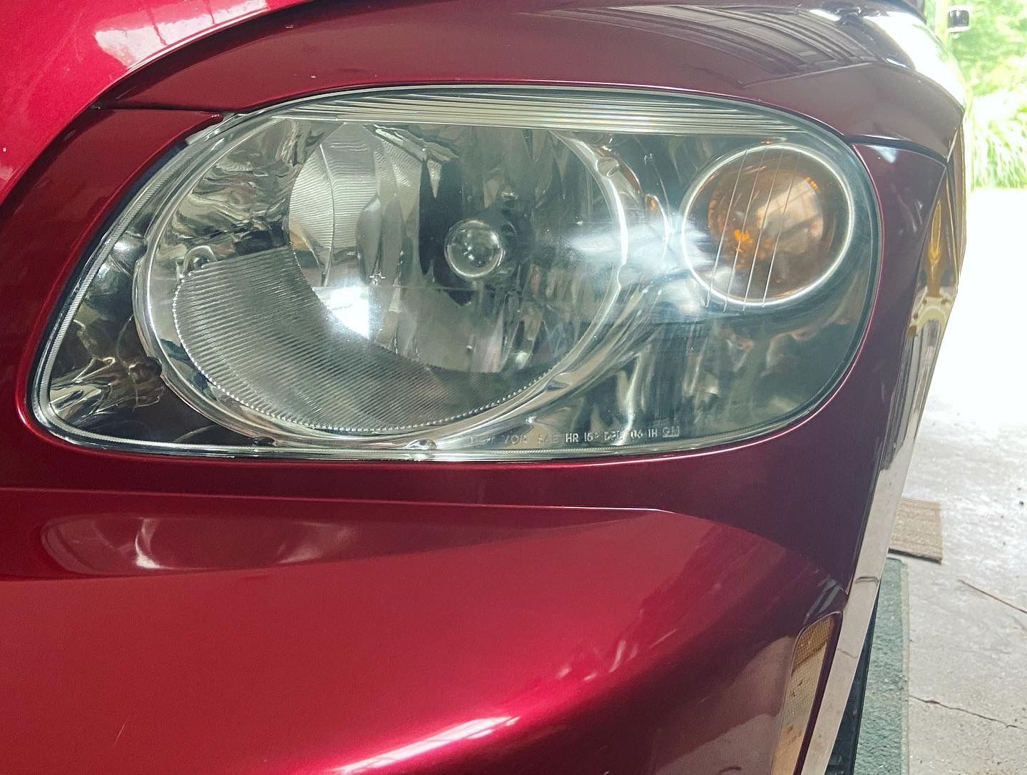A close up of a red car 's headlight in a garage.
