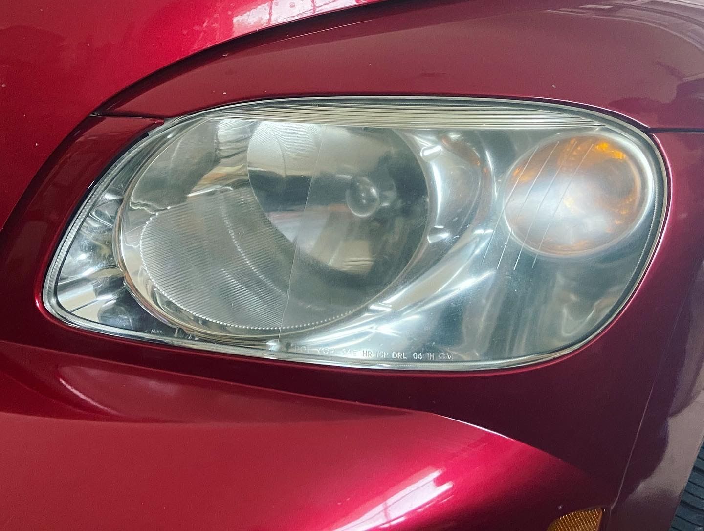 A close up of a red car 's headlight.