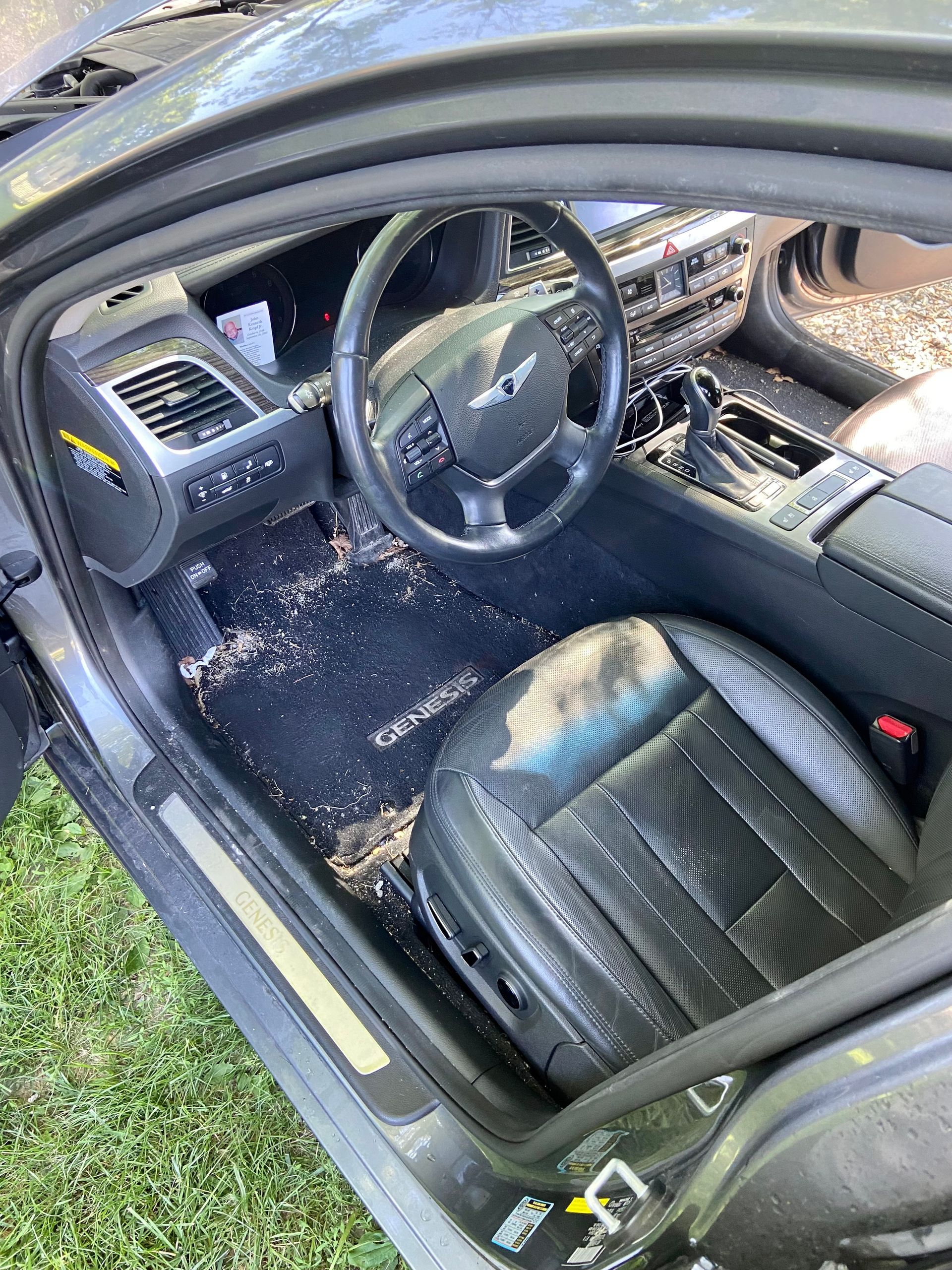 The inside of a dirty car with a steering wheel and seats.