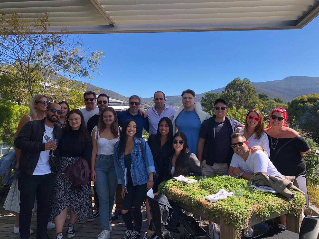 A group of people are posing for a picture in front of a table.