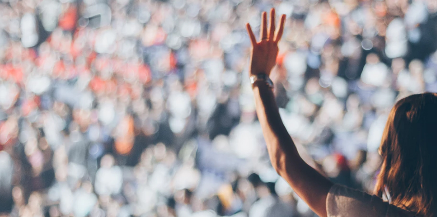 Person with arm raised towards a blurred crowd.