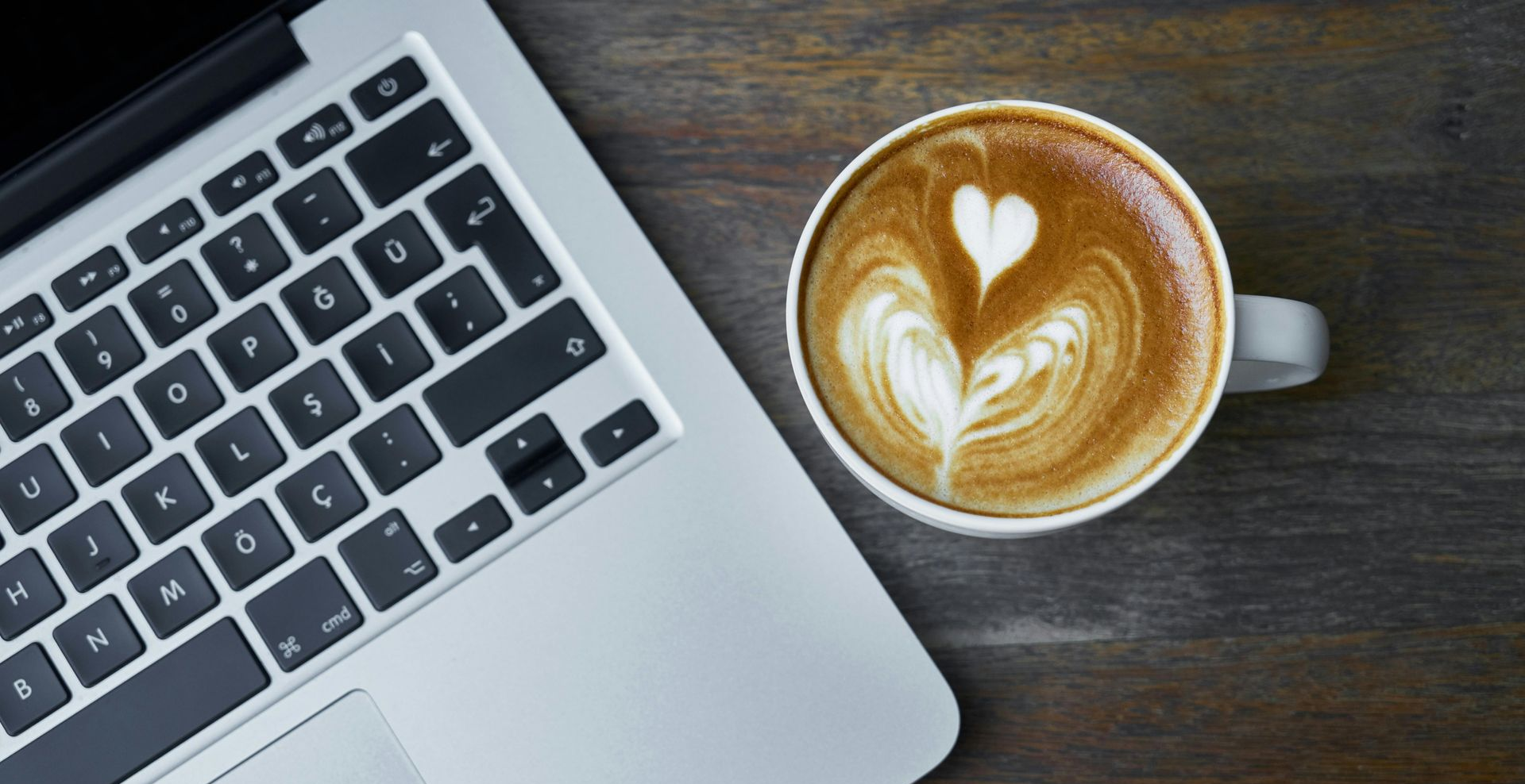 Palm trees silhouetted against a sky with hues of yellow and blue.