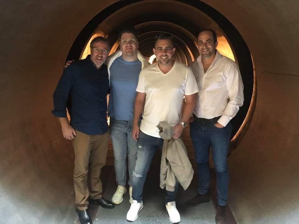 A group of men are posing for a picture in a tunnel.