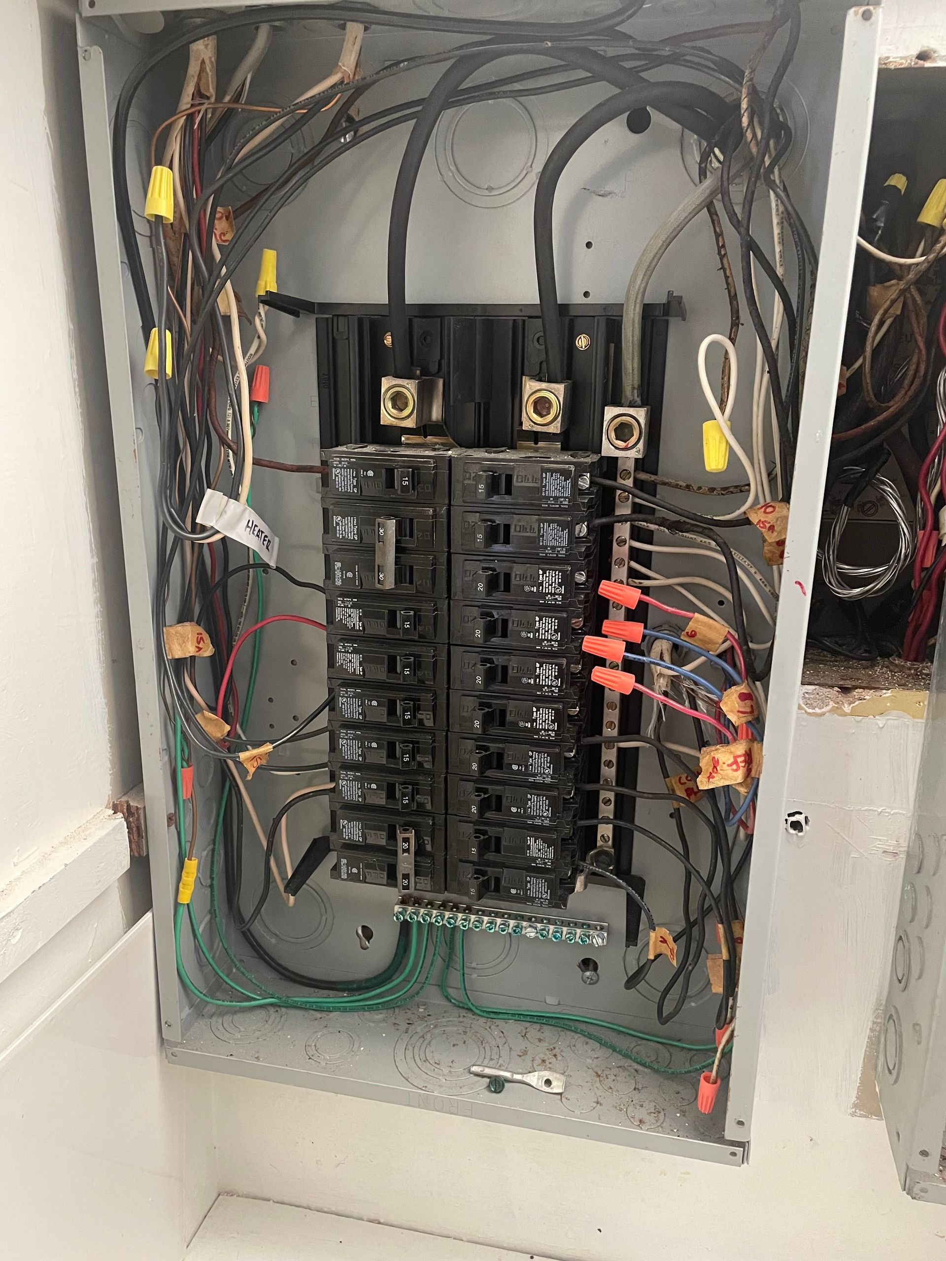 A very messy electrical box with a lot of wires coming out of it.