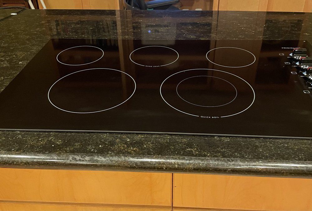 A black stove top with four circles on it