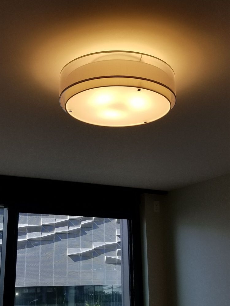 A ceiling light is hanging from the ceiling in a room next to a window.