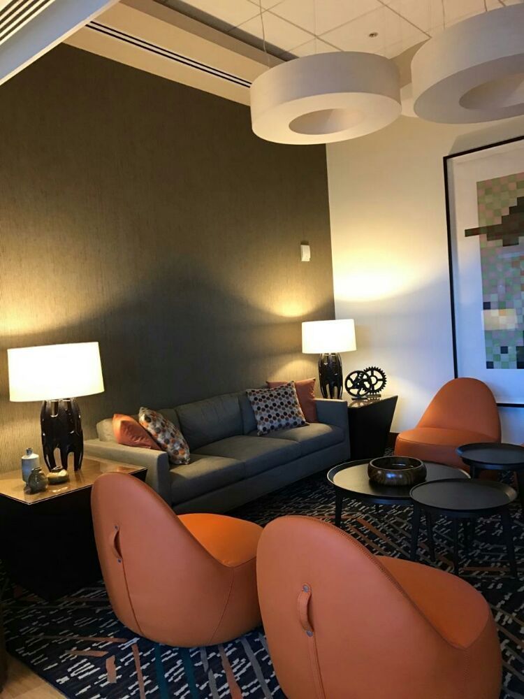 A living room with a couch and chairs and lamps