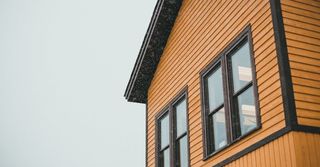 A close up of a wooden house with a lot of windows.