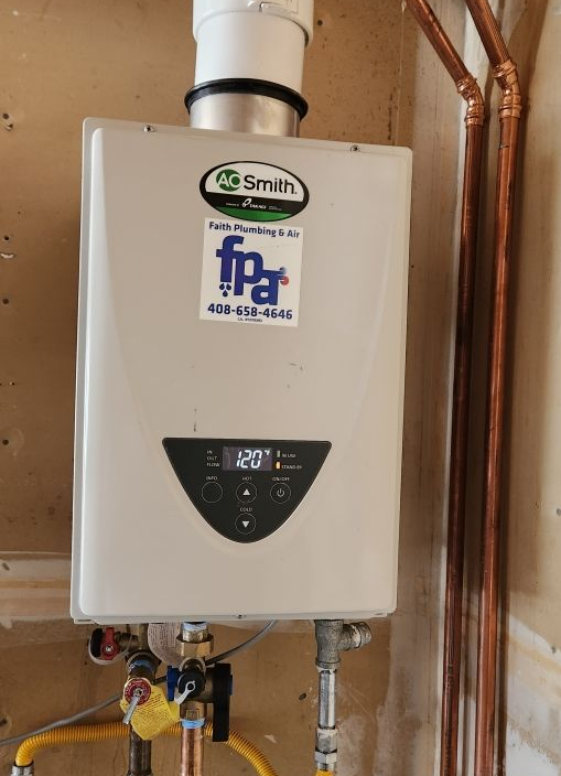 A tankless water heater mounted on a wall with copper pipes. It is a light beige color.