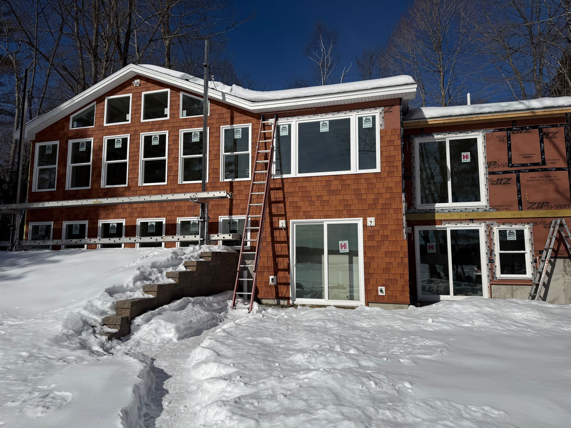 Gray roof on a house with dark trim and chimney.