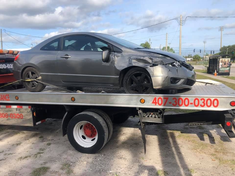A car is sitting on top of a tow truck.