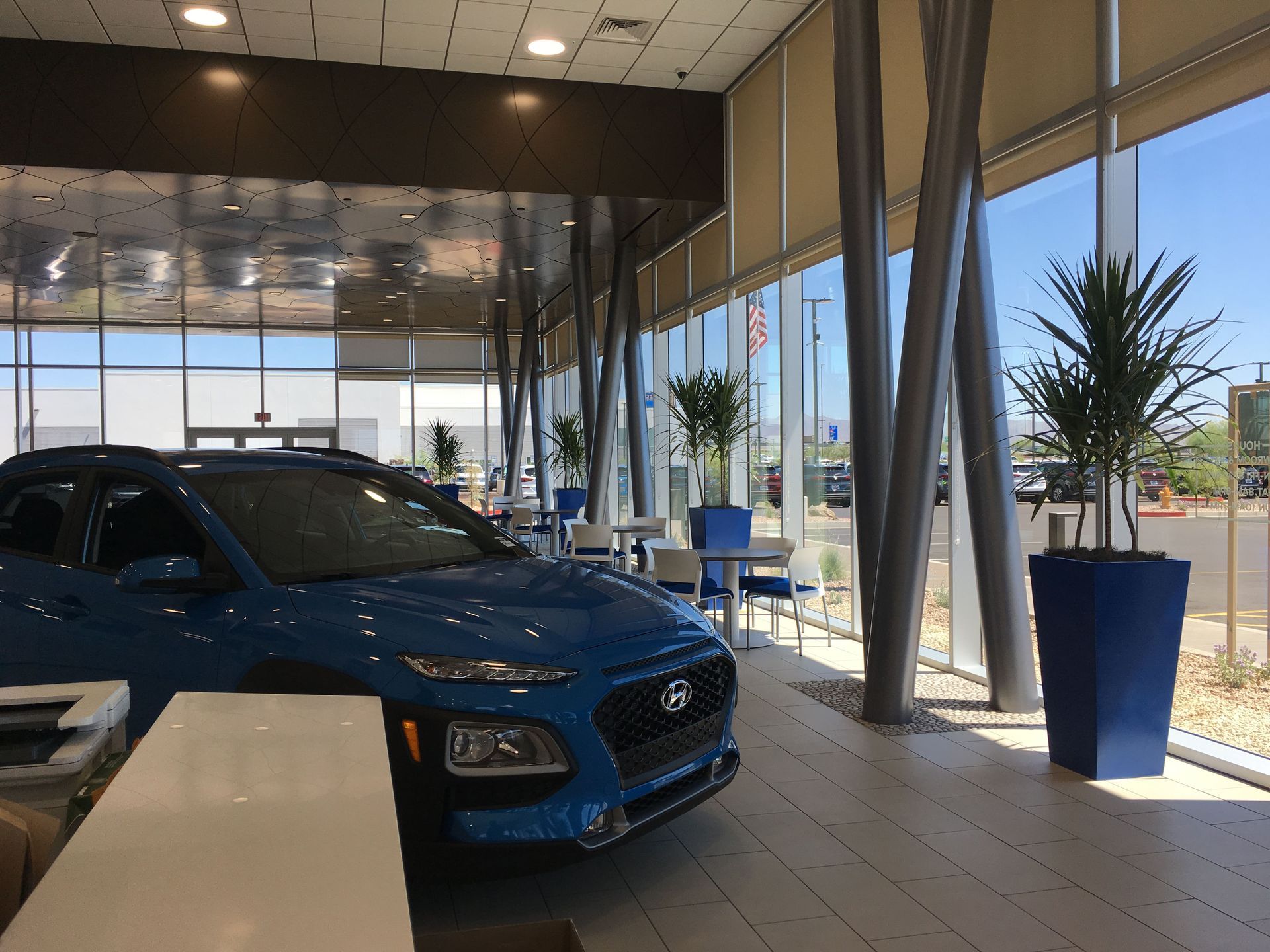 Courtyard with hammocks, planters, and seating. Beige buildings in the background under a sunny sky.