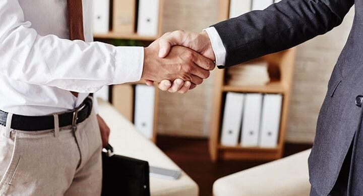 Dos hombres se dan la mano en una oficina.
