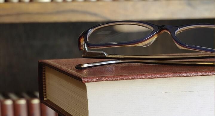 Un par de gafas están encima de un libro.