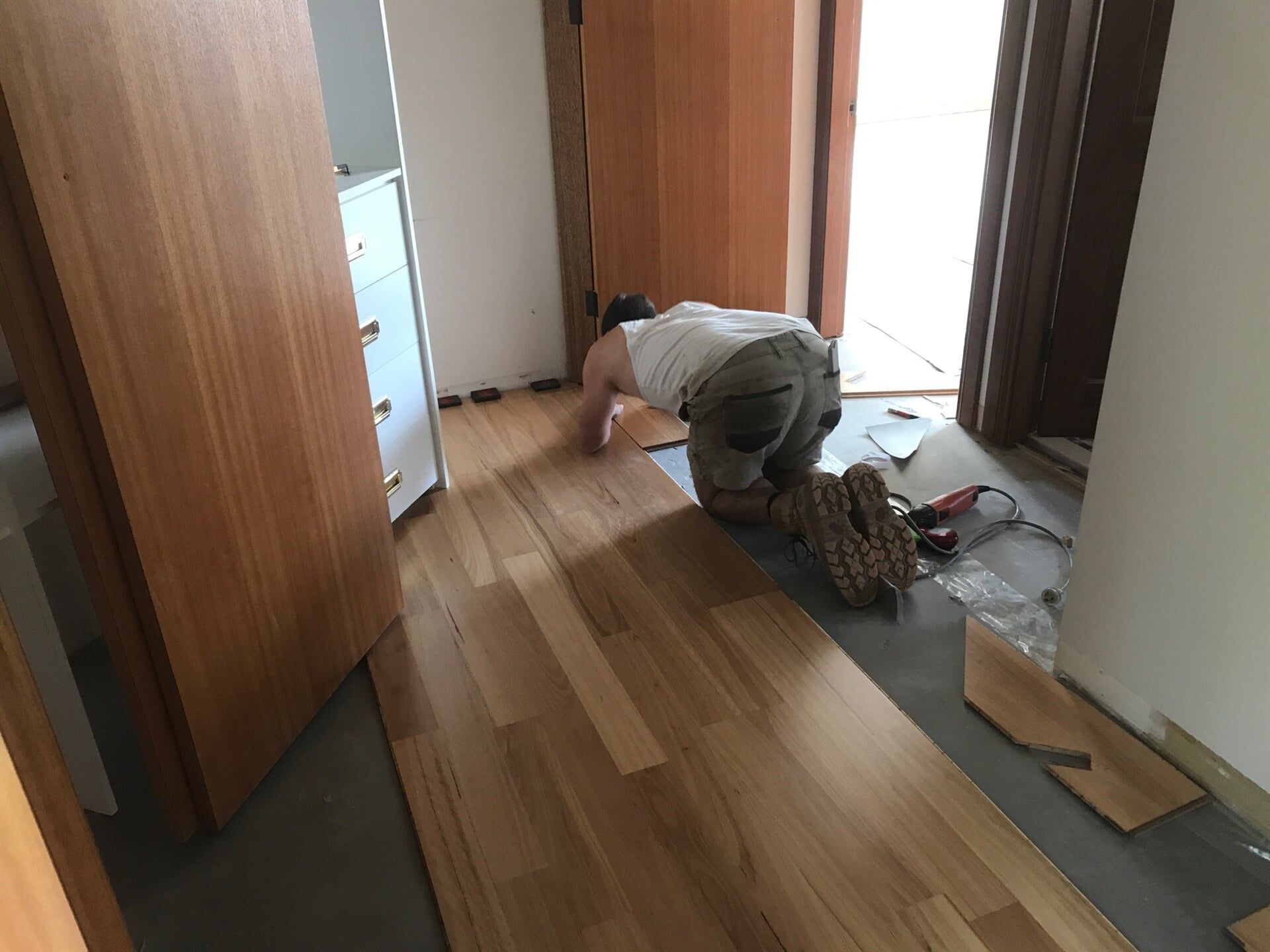 Man Installing Floorboard — Pacific Flooring in Bonville, NSW