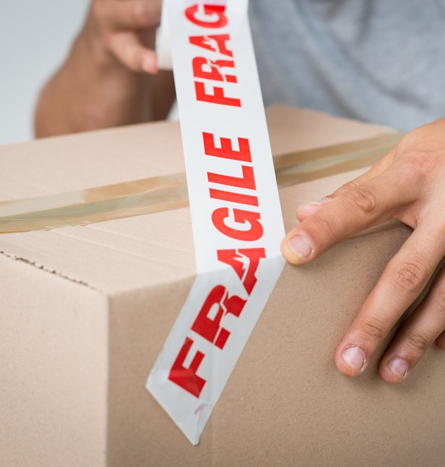 man placing fragile sign tap on packed box