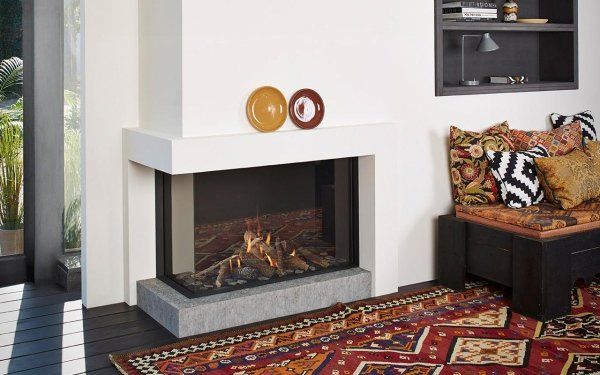 caminetto a gas angolare in acciaio e vetro con tappeto in una stanza