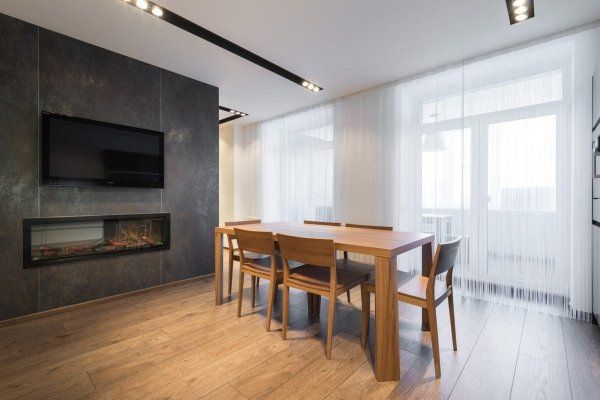 sala da pranzo con caminetto a parete e tenda trasparente bianco