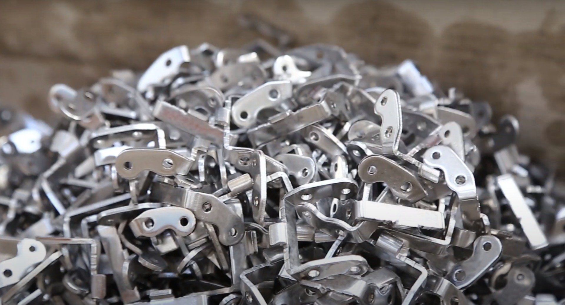 Mucchio di piccoli pezzi di ferramenta metallica lucida.