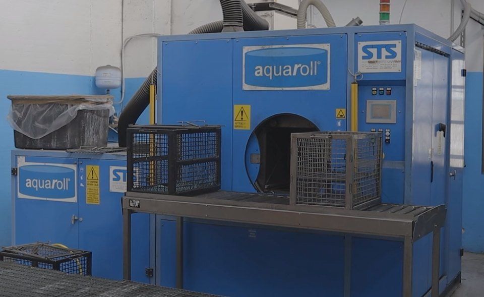 Lavatrice con casse blu e due casse nere, all'interno di una fabbrica.