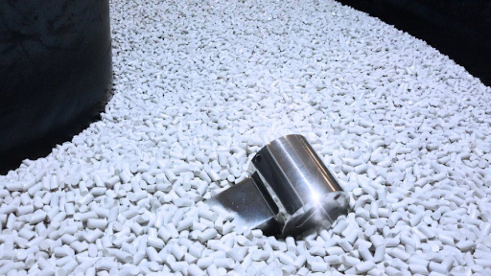 Una paletta di metallo affondò in un mucchio di palline bianche e cilindriche.