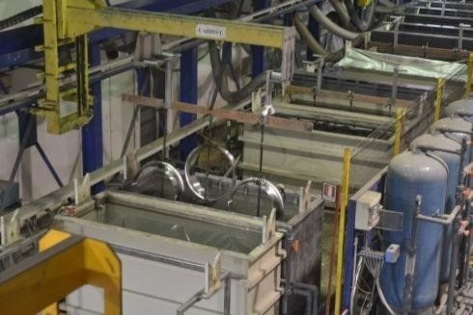 Processo di placcatura industriale con oggetti metallici immersi in vasche. Sistema di carroponte.