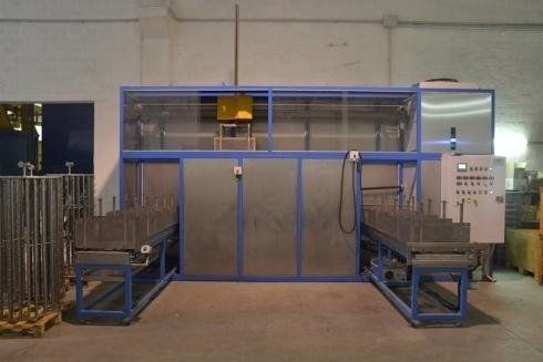 Lavatrice industriale per parti metalliche con telaio blu, pannello di controllo e nastri trasportatori.