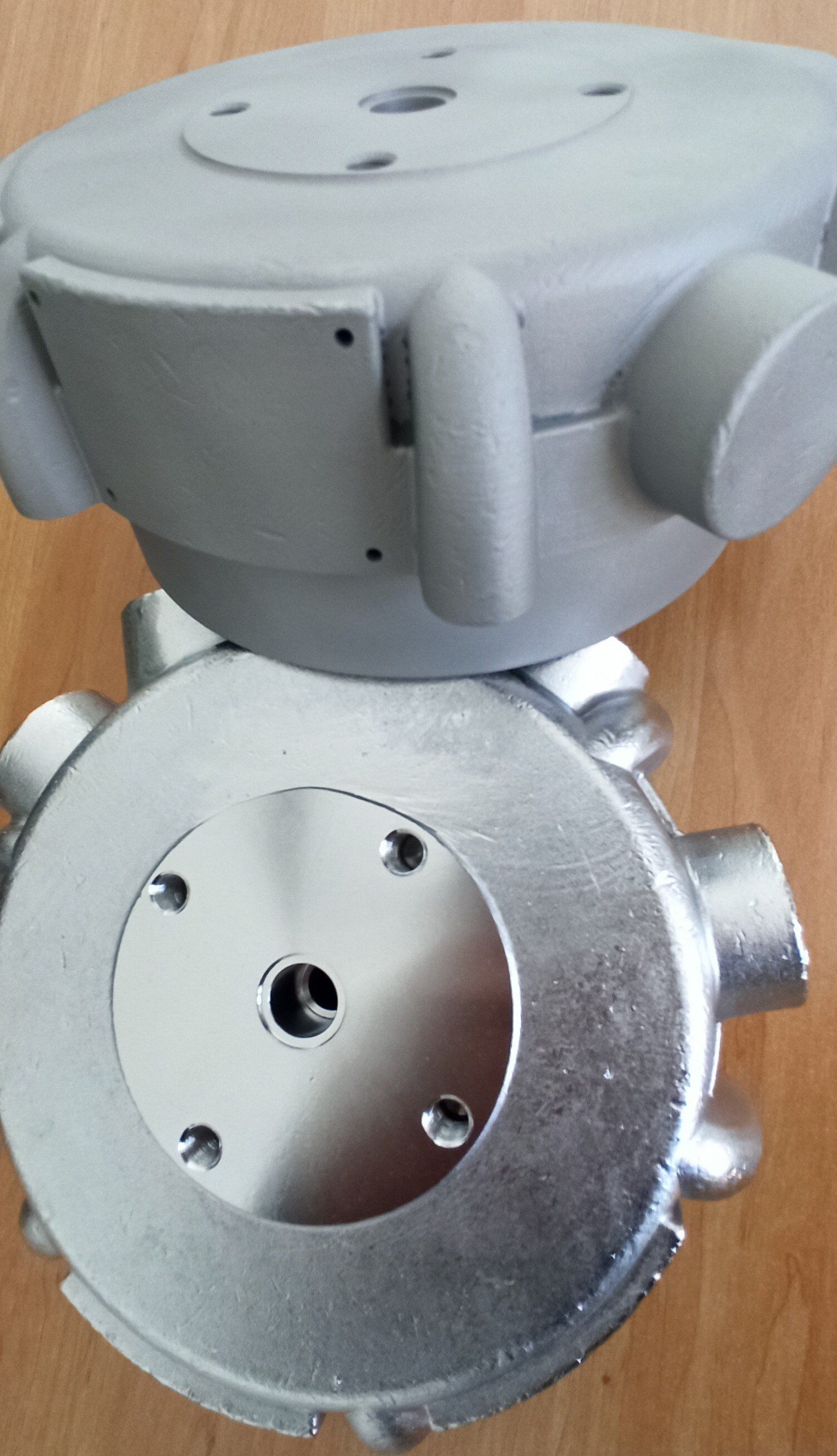 Due componenti metallici, uno arrotondato e uno circolare, probabilmente parti industriali.