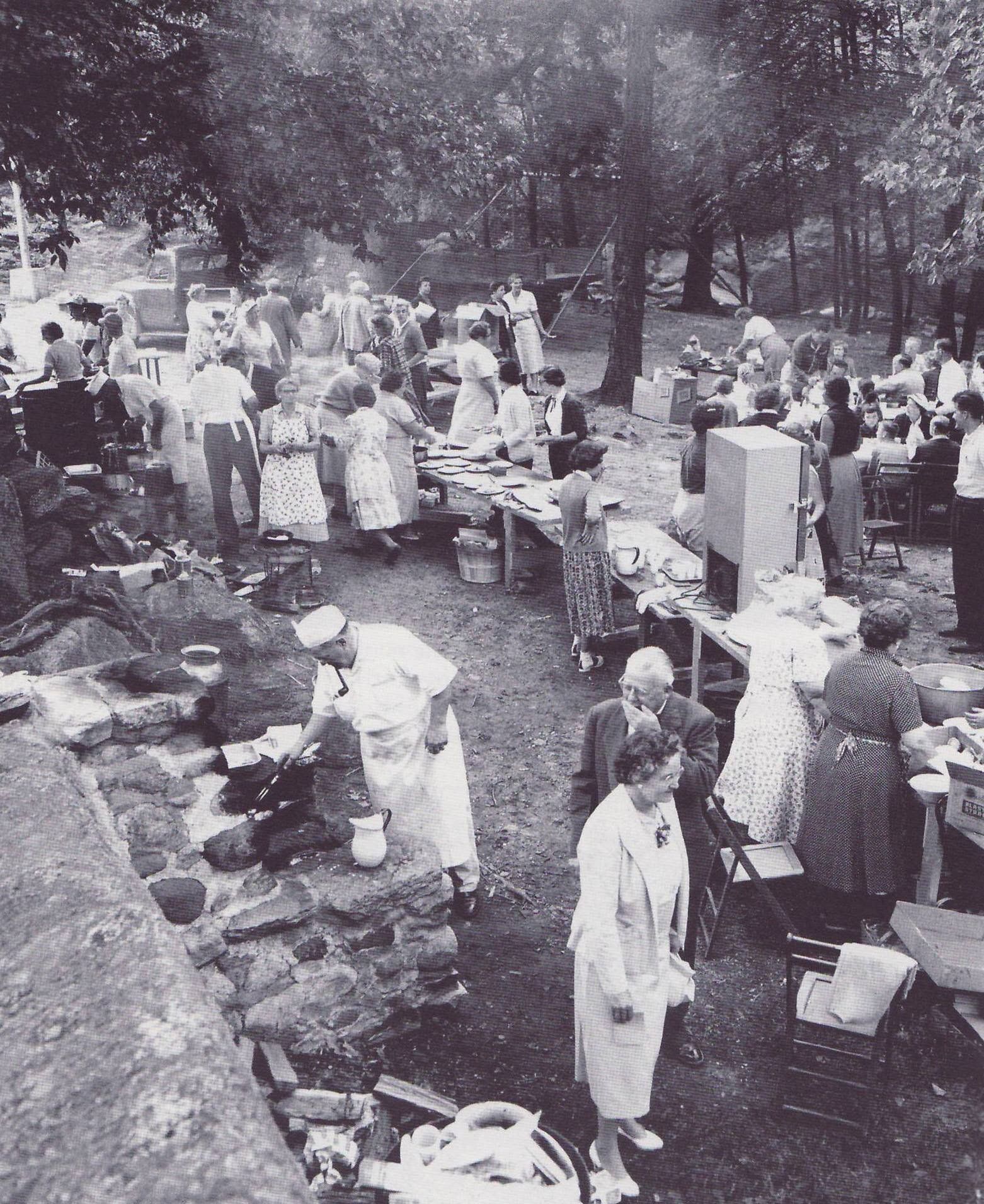 A black and white photo of a group of people in a park