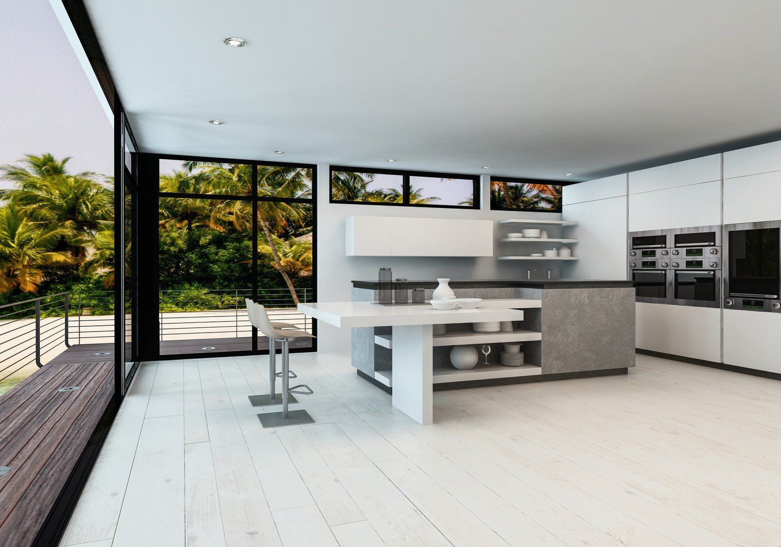 Modern white kitchen with island, floor-to-ceiling windows overlooking lush greenery.