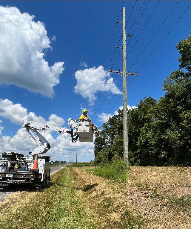 A man in a bucket is working on a power line