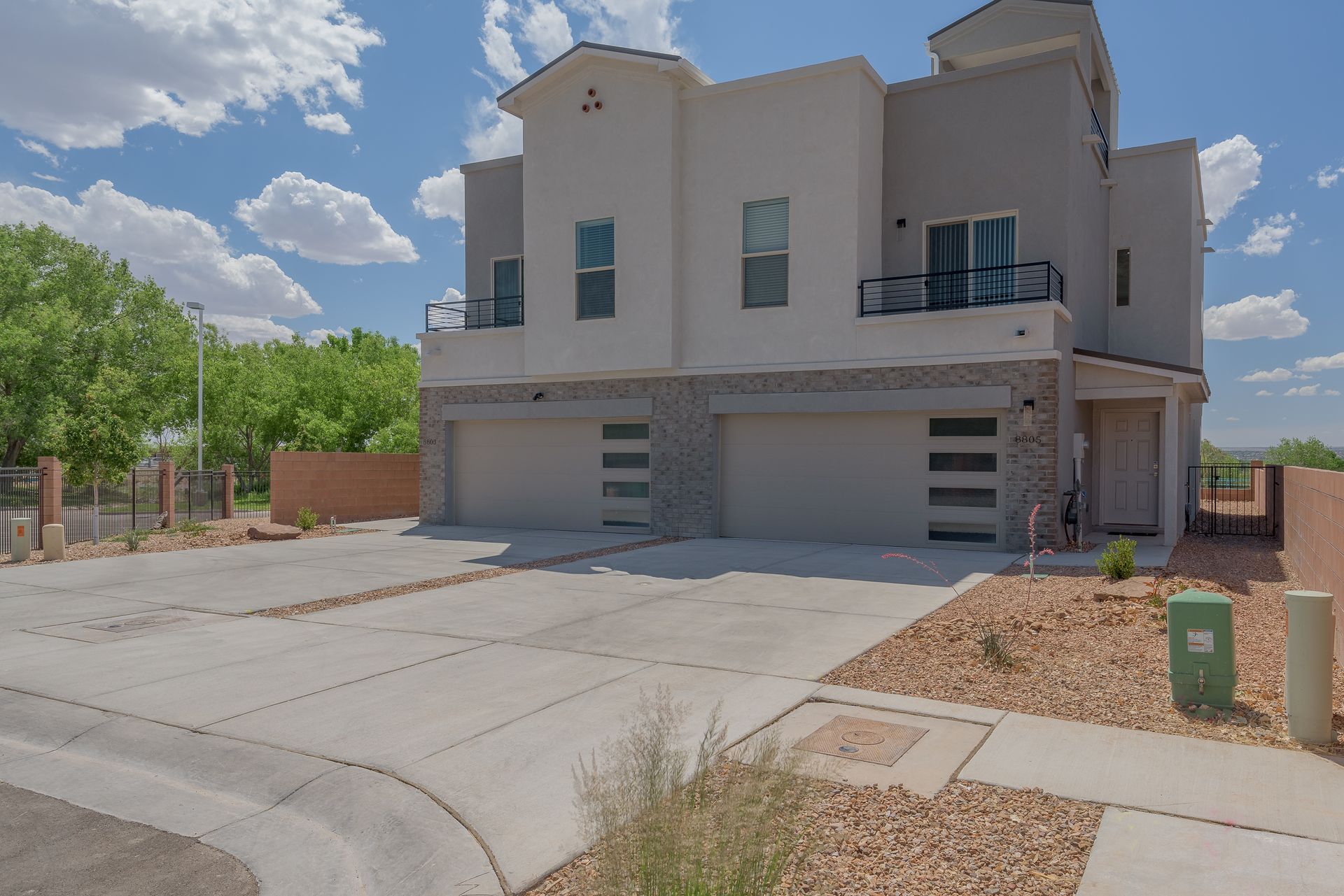 A large white house with three garages and a concrete driveway