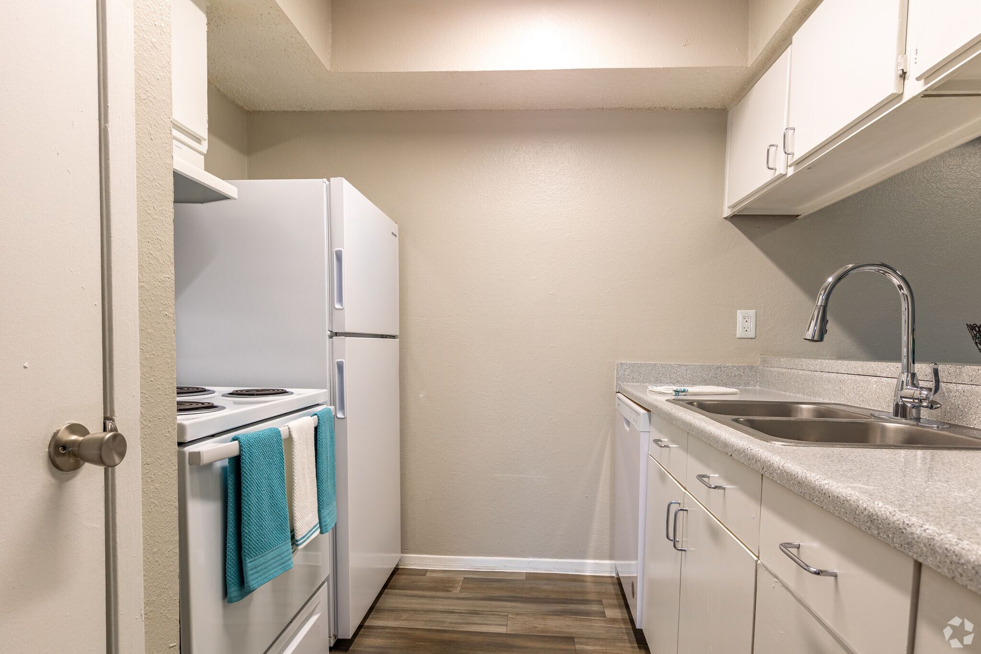 A kitchen with a refrigerator , stove , sink and dishwasher.