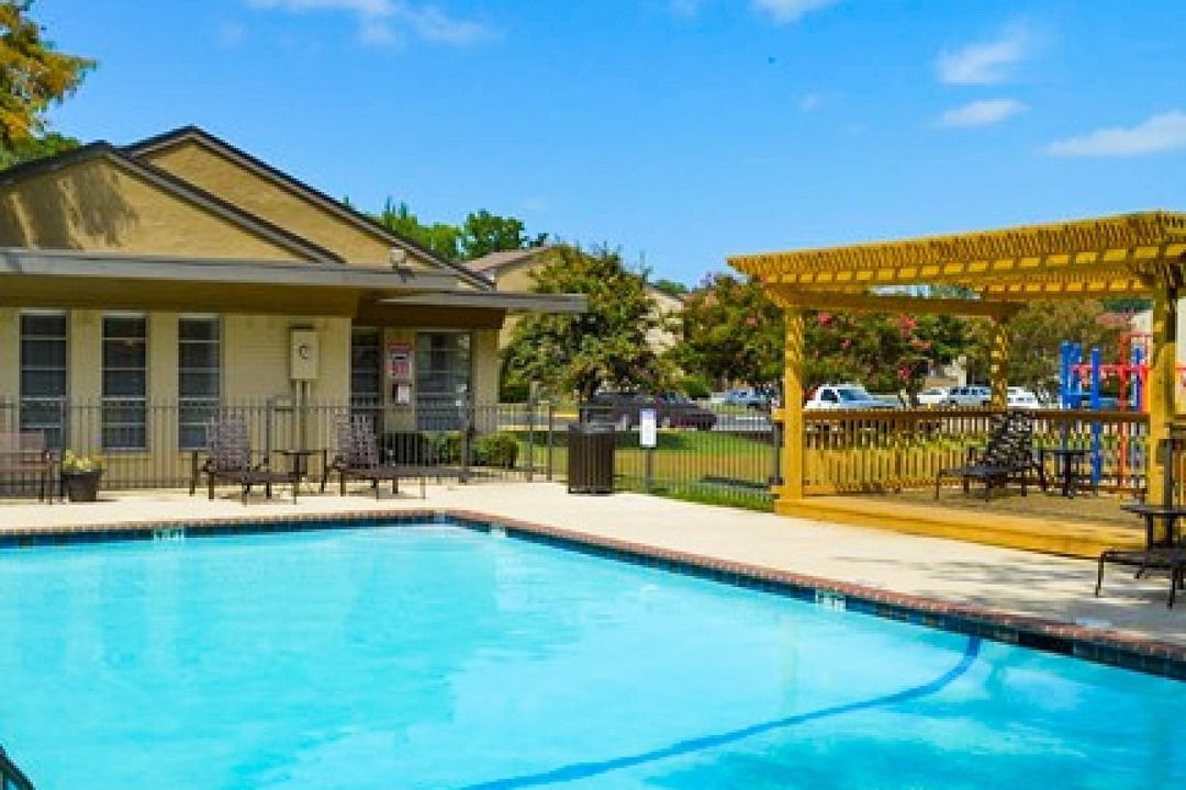 There is a large swimming pool in front of a house.