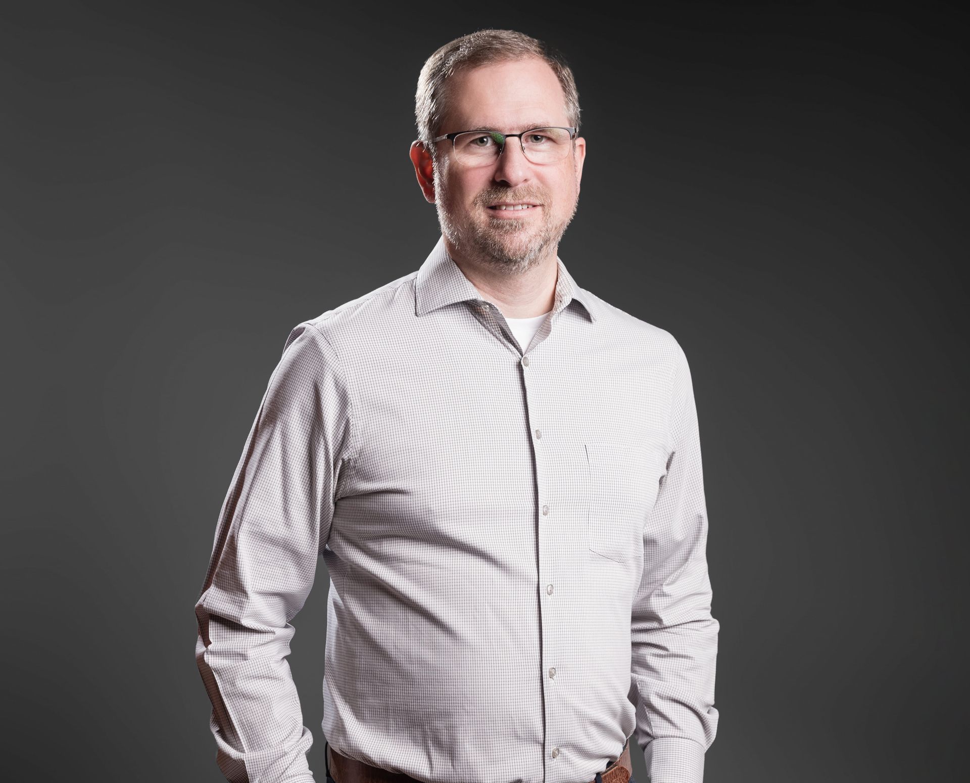 Um homem de terno e gravata está sorrindo para a câmera