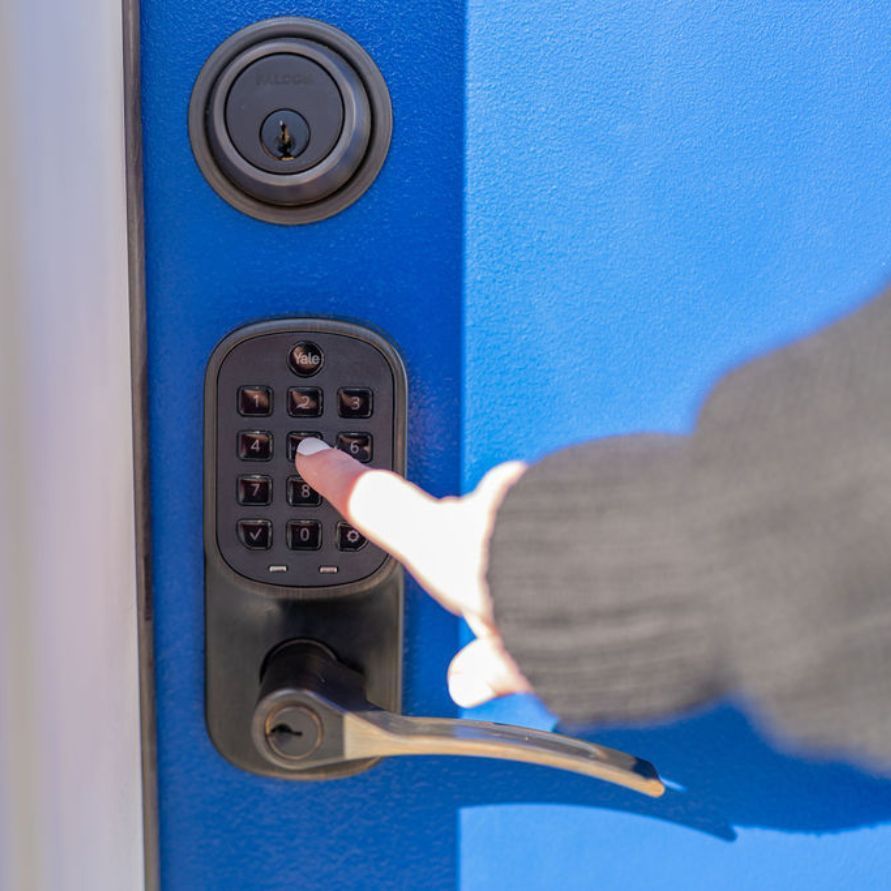 Photo of woman using contactless keypad on hotel room door.