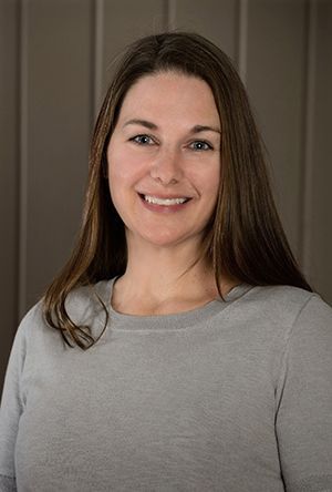 A woman in scrubs is standing next to a counter that says ' weedvale ' on it