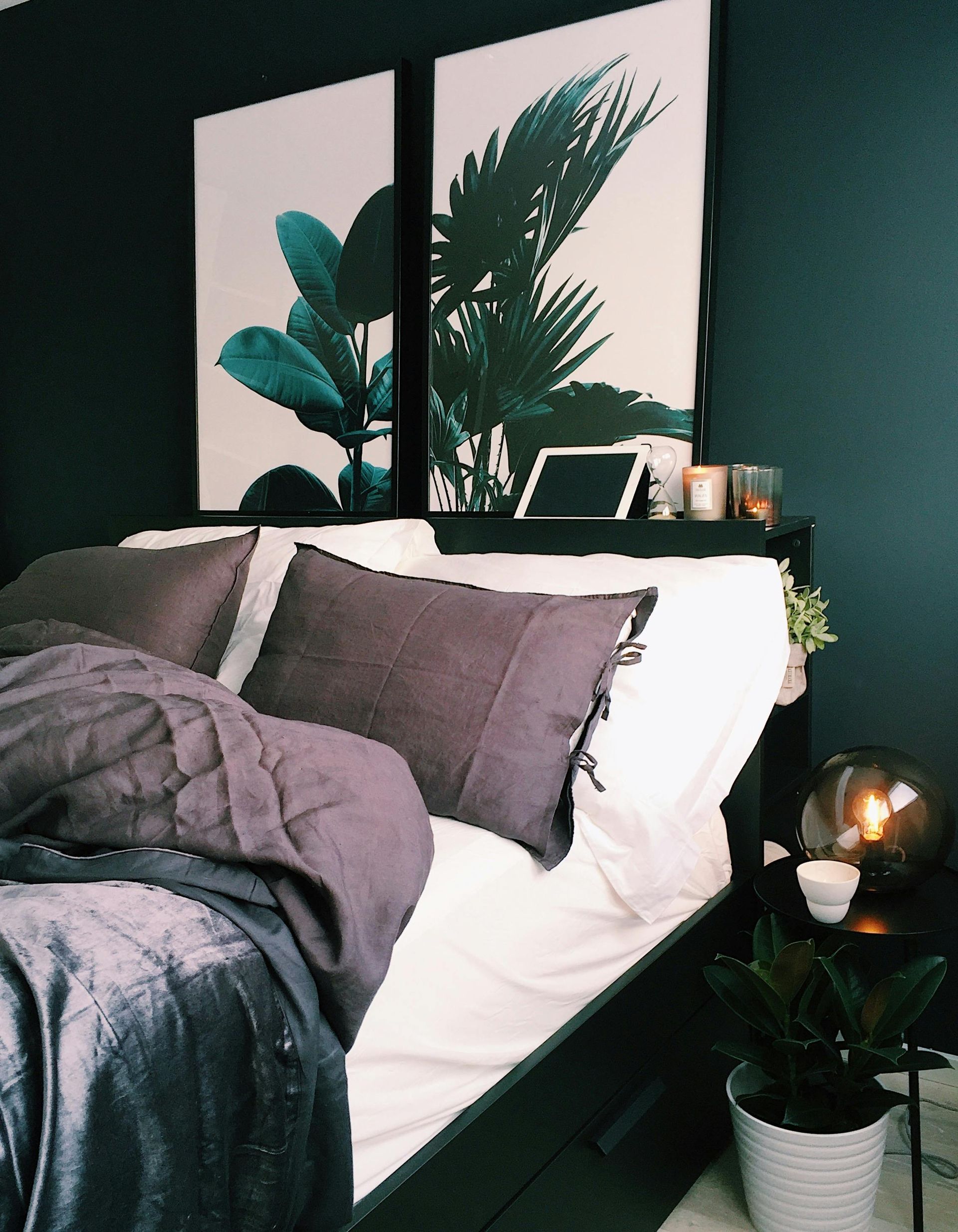 A bedroom with a bed and two paintings on the wall