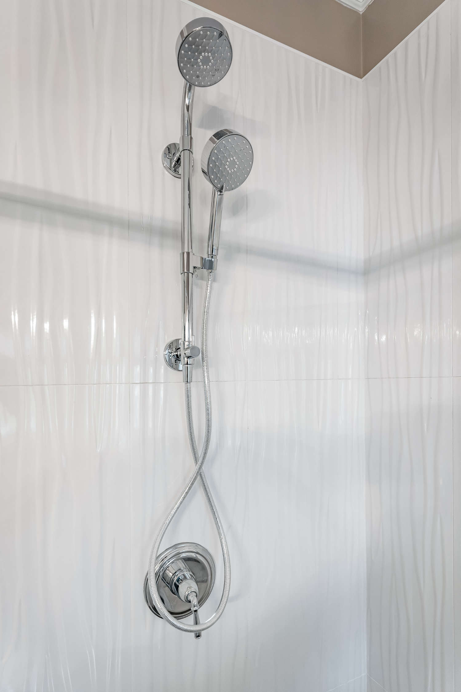 A shower head is hanging from the ceiling in a bathroom.