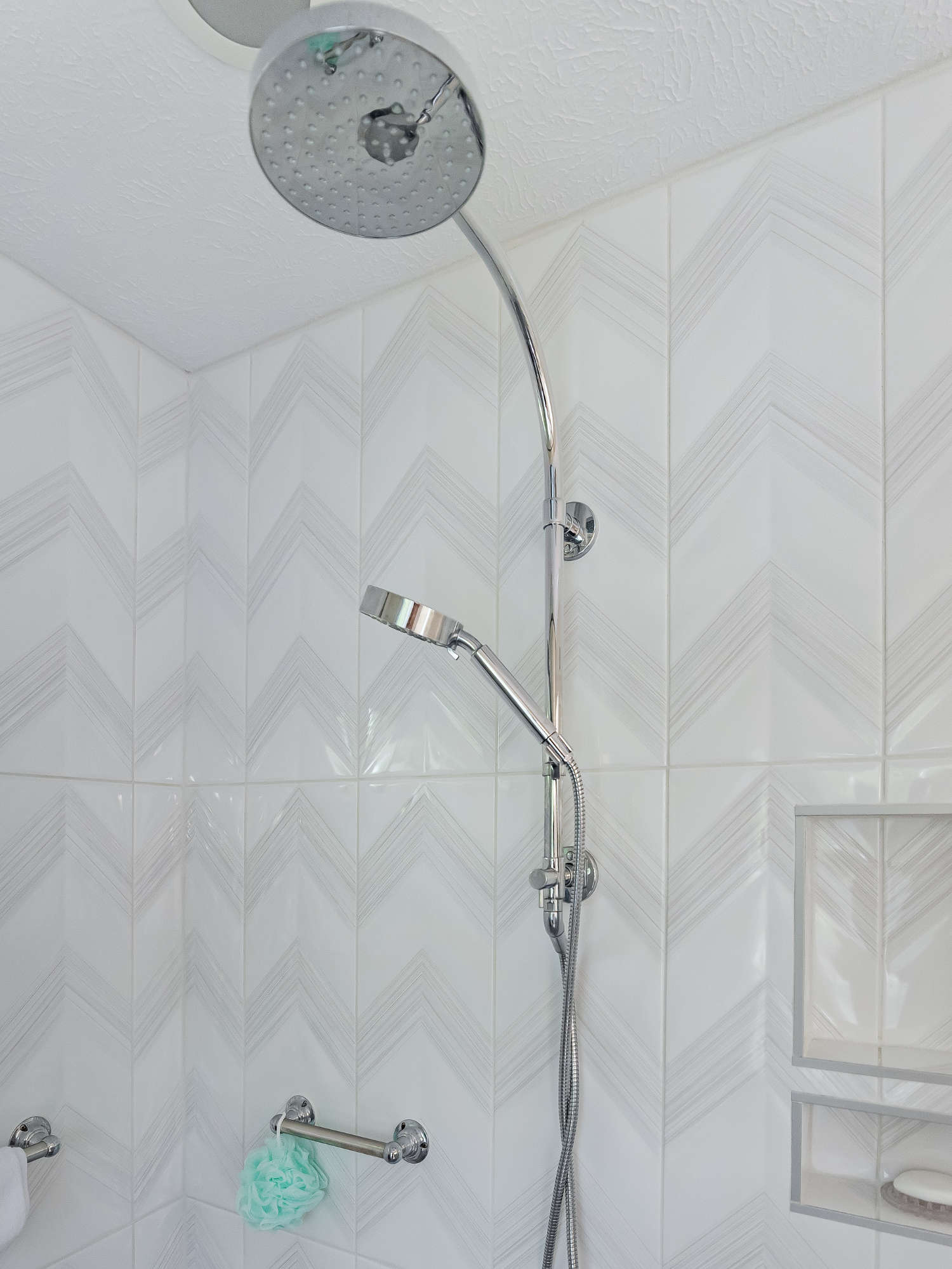 A shower head is hanging from the ceiling in a bathroom