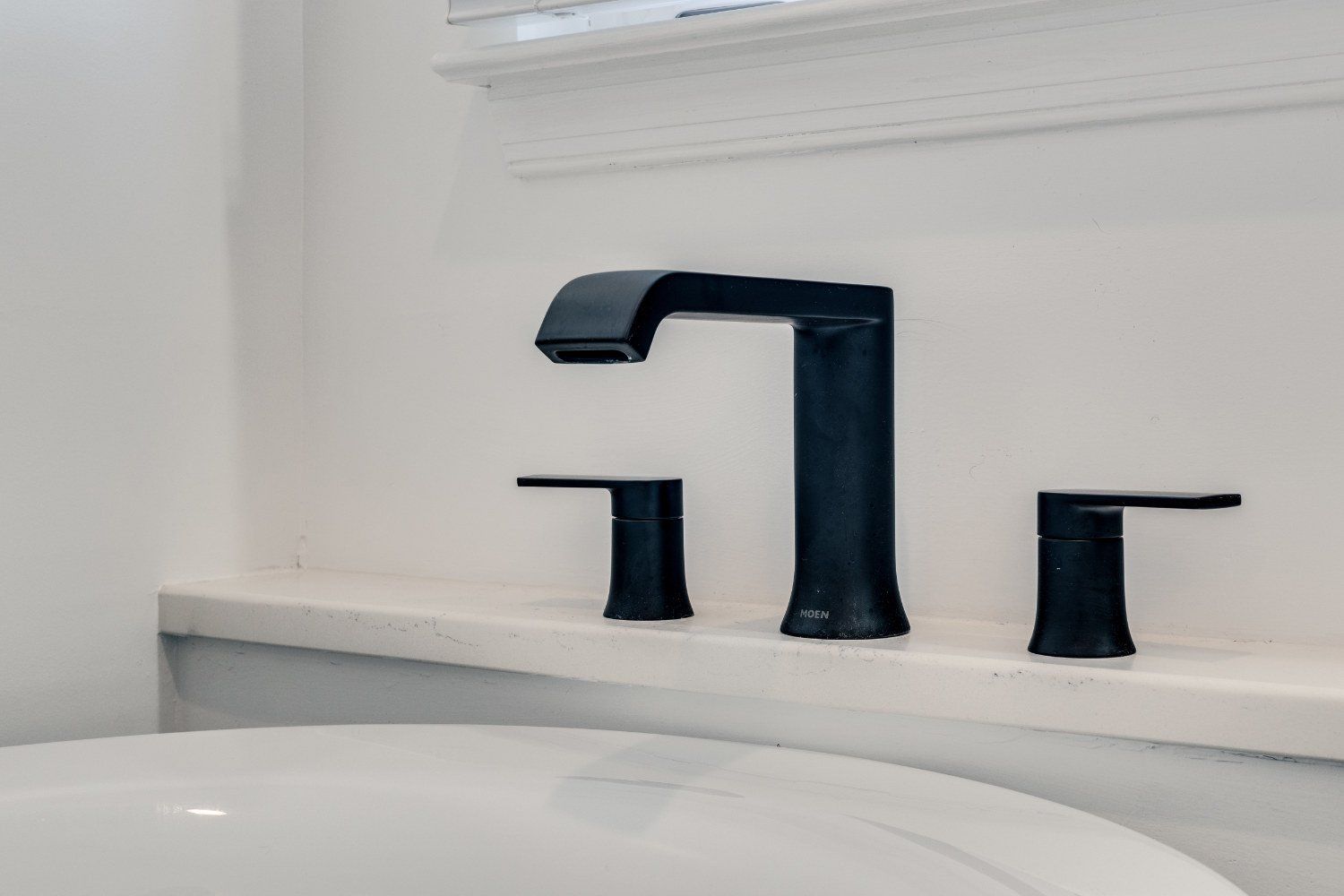 A bathroom with a black faucet and a white bathtub.