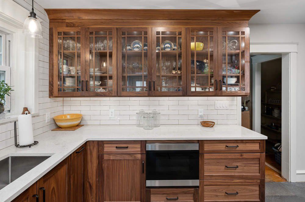 A kitchen with wooden cabinets and white counter tops.