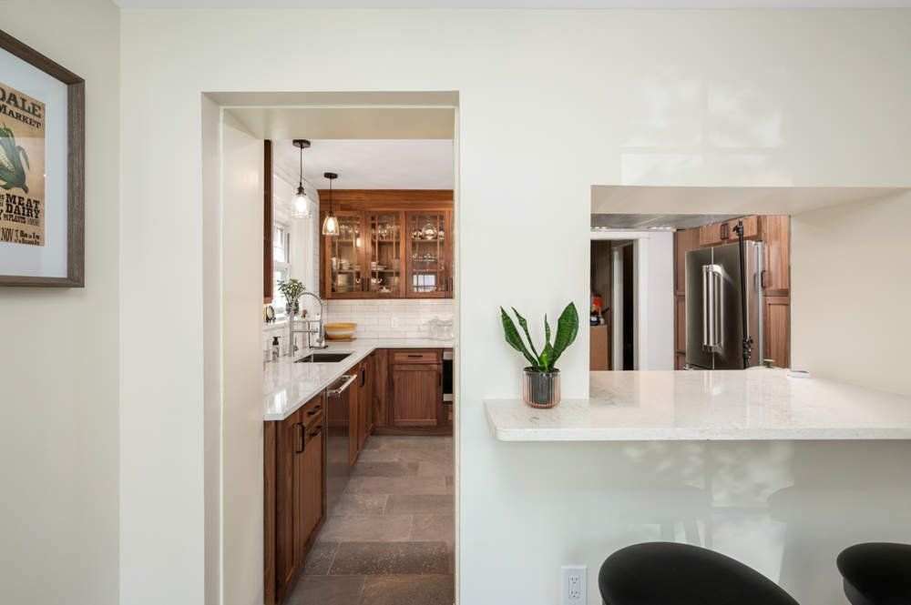 A kitchen with wooden cabinets and a white counter top.