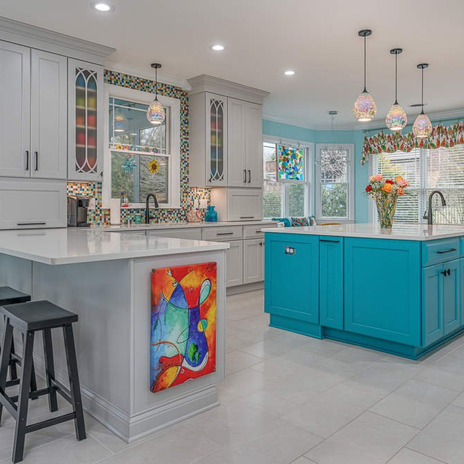 A kitchen with blue cabinets and white cabinets and a large island.